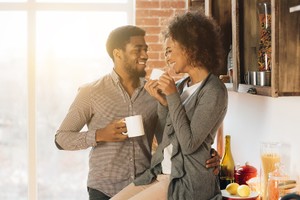 Happy morning together. Cute young african-american couple drinking coffee in cozy kitchen, panorama, copy space taking care of birth control side effects